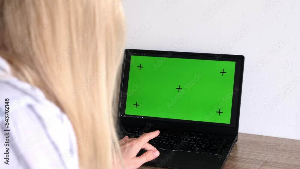 Education, online school and distant learning concept - student woman with green screen on laptop computer with motion tracking markers and notebook at home. Education, online school and distant learning concept - student woman with green screen on laptop computer with motion tracking markers and notebook at home.