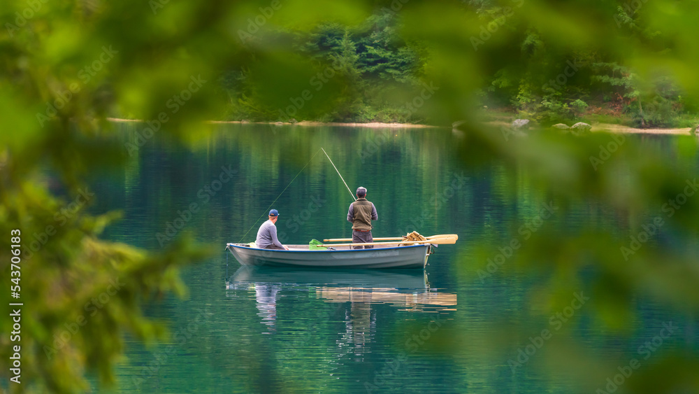 Zwei Angler in einem kleinen Boot auf einem idyllischen See
