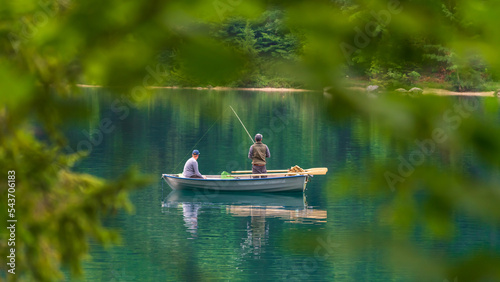 Zwei Angler in einem kleinen Boot auf einem idyllischen See