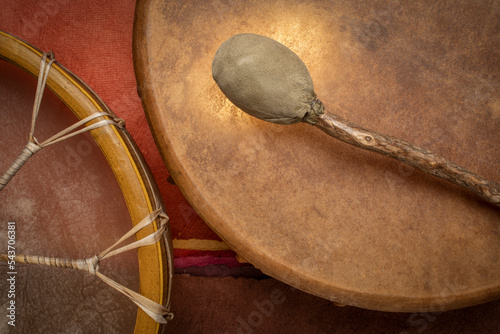 two handmade, native American style, shaman frame drums covered by goat skin with a beater photo