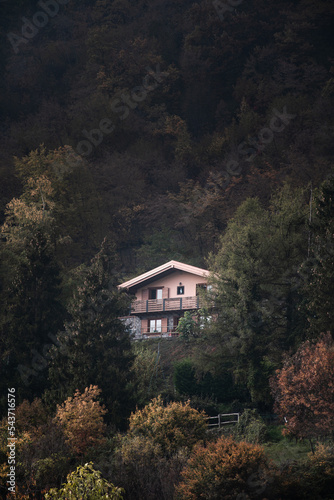 A solitary house hidden in the forest during a moody autumn day in the Northern Italy