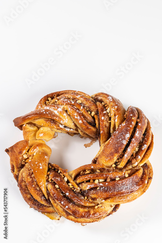 Roscón de reyes Kringle Estonia. Typical Christmas sweet, braided sponge cake with cinnamon, butter, walnuts or almonds and icing sugar on a white background