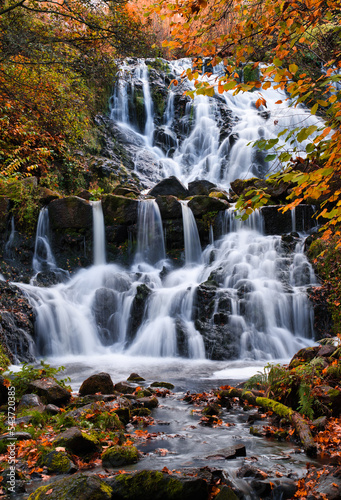 Beautiful waterfall in autumn forest in Jonkoping, Sweden. Long exposure. Selective focus.