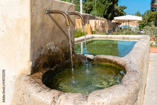 Picturesque drinking fountain on the Plaza of Scopello in the north of Sicily. A hamlet of houses clustered around a common courtyard and a public square