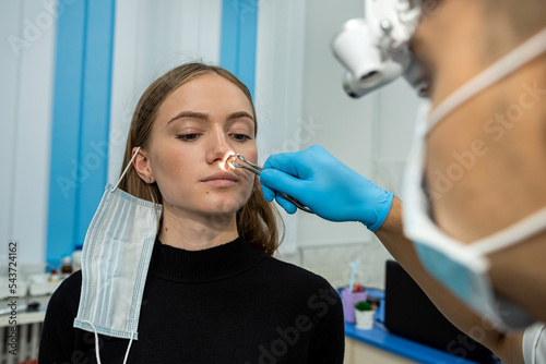  otolaryngologist while working with a girl patient on an examination of the sinuses. photo
