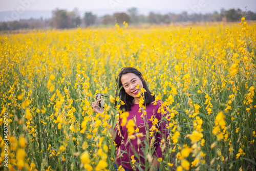 Young woman in a field of yellow flowers