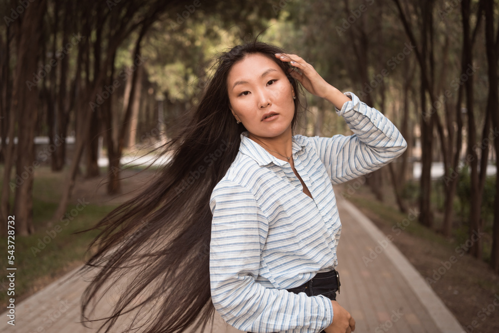 portrait of Asian woman with long black hair in city park portrait of Asian woman with long black hair in city park