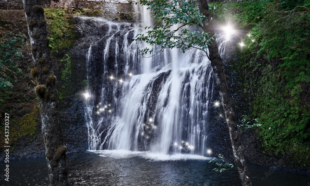 Obraz premium Waterfall with fairy sparks of shimmering light in magical forest