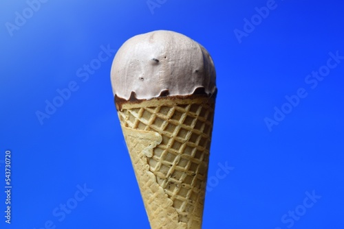 Cono de helado de chocolate sobre fondo azul photo