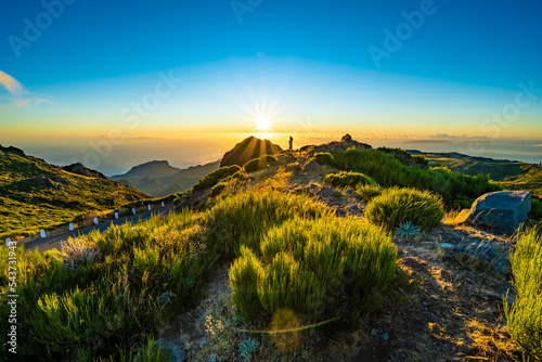 Woman enjoying beautiful mountain landscape of Pico do Ariero during sunrise. Pico do Arieiro, Madeira Island, Portugal, Europe.