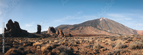 Panorama of caldera in Teide National Park, Tenerife, Canary Islands, Spain. Roques de Garcia in the foreground and snow covered mount Pico del Teide in the background. photo