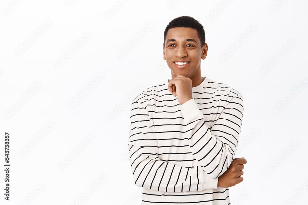 Portrait of smiling black man looking interested in smth, listetning to you, standing over white background Portrait of smiling black man looking interested in smth, listetning to you, standing over white background