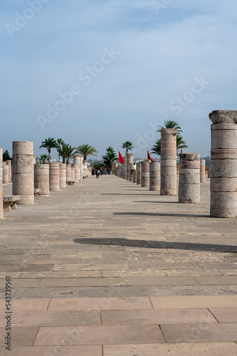 People walking around the medieval columns next to the Hassan tower in Rabat, Morocco
