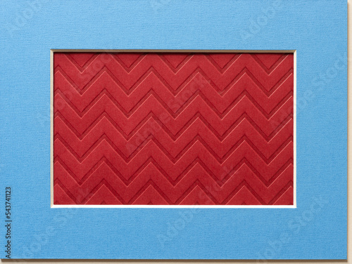 grungy red brown paper with chevron pattern framed in blue mat with beveled edge photo