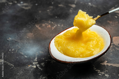 Homemade Melted ghee clarified butter. Bio Ayurveda Lactose free high quality butter on a dark background. place for text