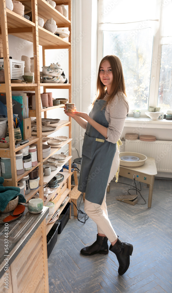 Female ceramist and her new collection of ceramic tableware in the studio of clay and sculpture.