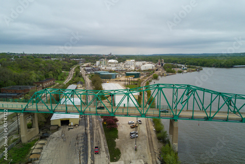 Aerial drone photo of a green railroad bridgge going over river water and land. photo