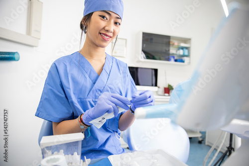 Female dentist in the dental clinic while preparing the working tools