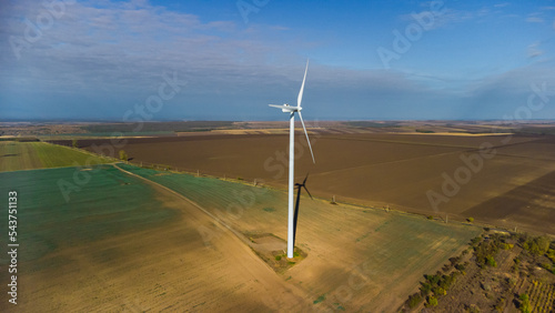 Wind turbines standing in the field from the drone point of view