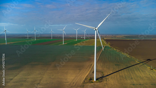 Wind turbines standing in the field from the drone point of view