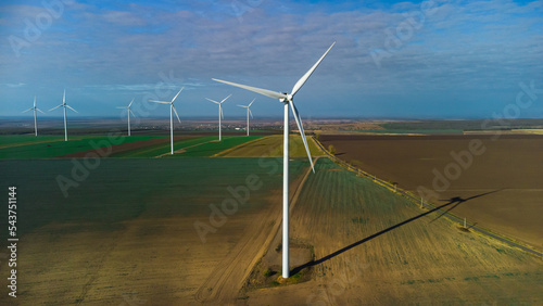 Wind turbines standing in the field from the drone point of view