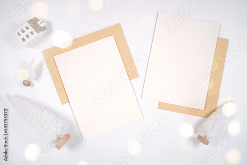 Christmas two sides 5x7 greeting card, party invitation mockup, styled with white reindeer and mini trees, bokeh party fairy lights on a minimalist white background. photo