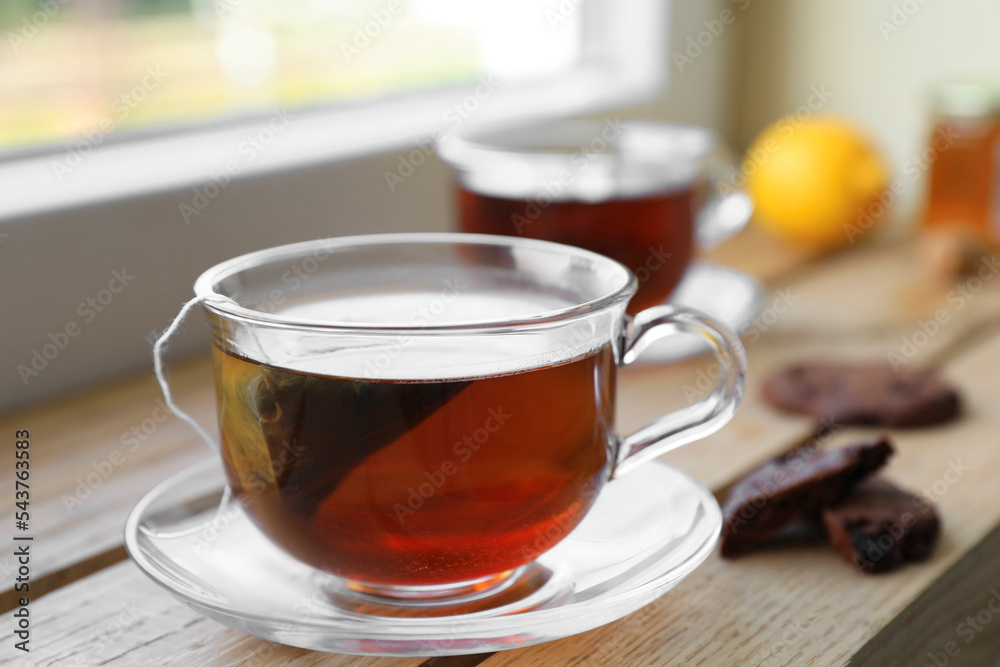Bag of black tea in cups on wooden table indoors Bag of black tea in cups on wooden table indoors
