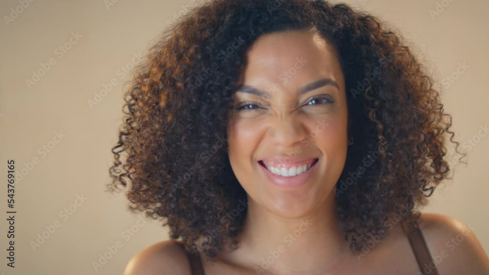 Studio close up shot of confident and positive young woman laughing at camera - shot in slow motion Studio close up shot of confident and positive young woman laughing at camera - shot in slow motion