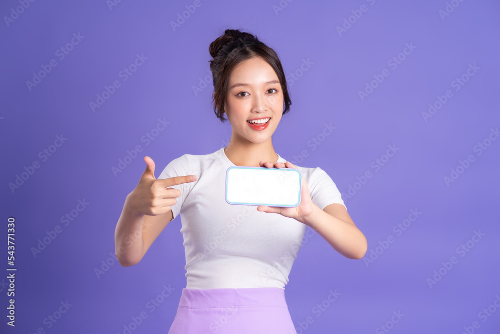 Portrait of a beautiful Asian woman posing on a purple background
