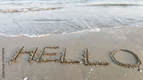  A word hello by handwriting on the beach and sea wave