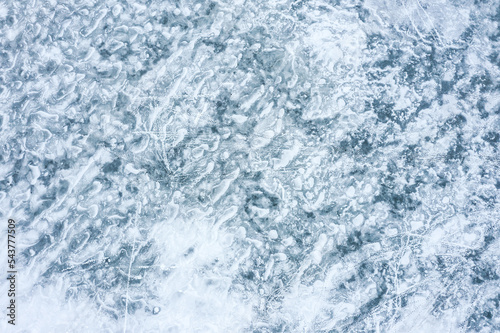 frozen background of the lake with ice of ribbed texture. aerial top drone view from above.