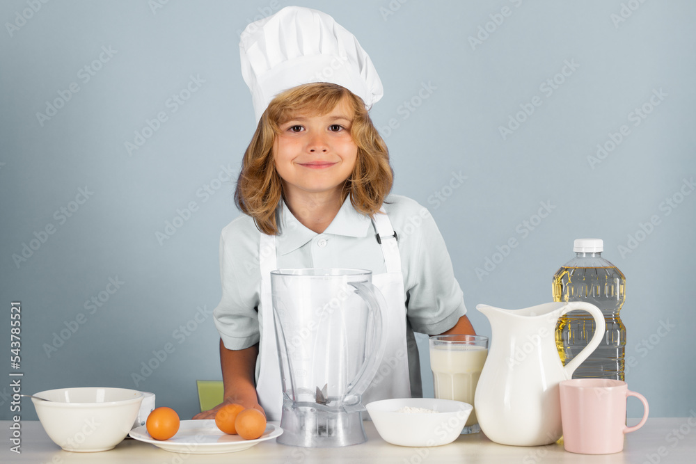 Cooking children. Chef kid boy making fresh vegetables for healthy eat. Portrait of little child in form of cook isolated on grey background. Kid chef. Cooking process. Cooking children. Chef kid boy making fresh vegetables for healthy eat. Portrait of little child in form of cook isolated on grey background. Kid chef. Cooking process.