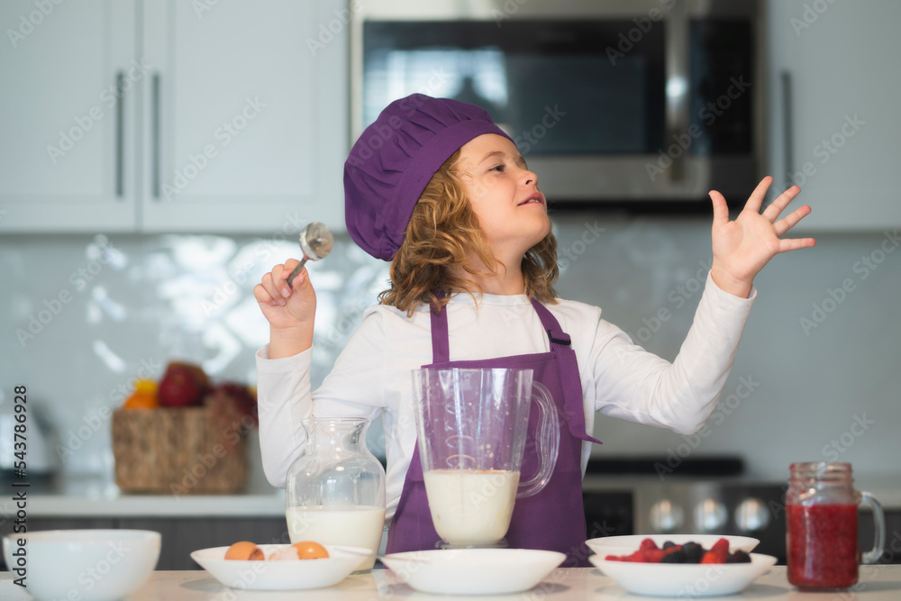 Chef child cooking healthy meal and dinner preparation. Chef kid boy in apron and chef hat cooking at kitchen. Healthy food. Chef child cooking healthy meal and dinner preparation. Chef kid boy in apron and chef hat cooking at kitchen. Healthy food.