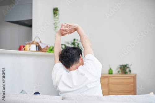 家で伸びをする男性 photo