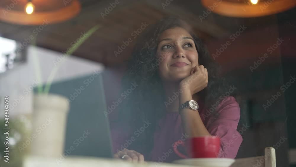 Happy Young freelance business Indian woman working at laptop in coffee shop , online conference distance office chat, Working from cafe, Working remotely and Self learning at cafe.