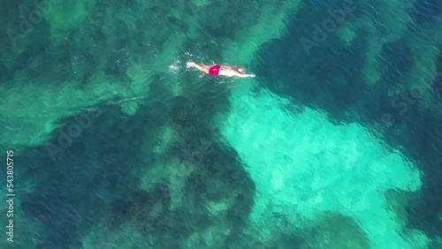 aerial view of joung man swiming on cristal clear waters on a beach of mallorca. Concept of holiday, summer, travel, tourism and relax	 photo