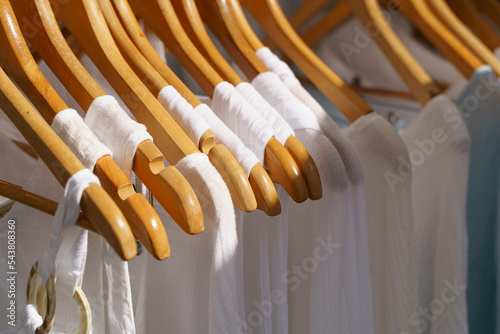 Organic eco clothes on a hanger. Home-made white clothing from natural and processed fabrics, natural vegetable ingredients. Eco-friendly dresses and shirts photo