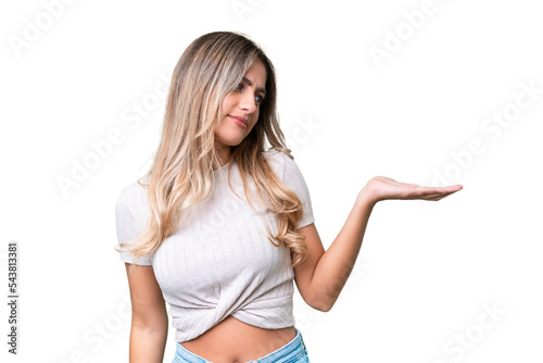 Young Uruguayan woman over isolated background holding copyspace with doubts