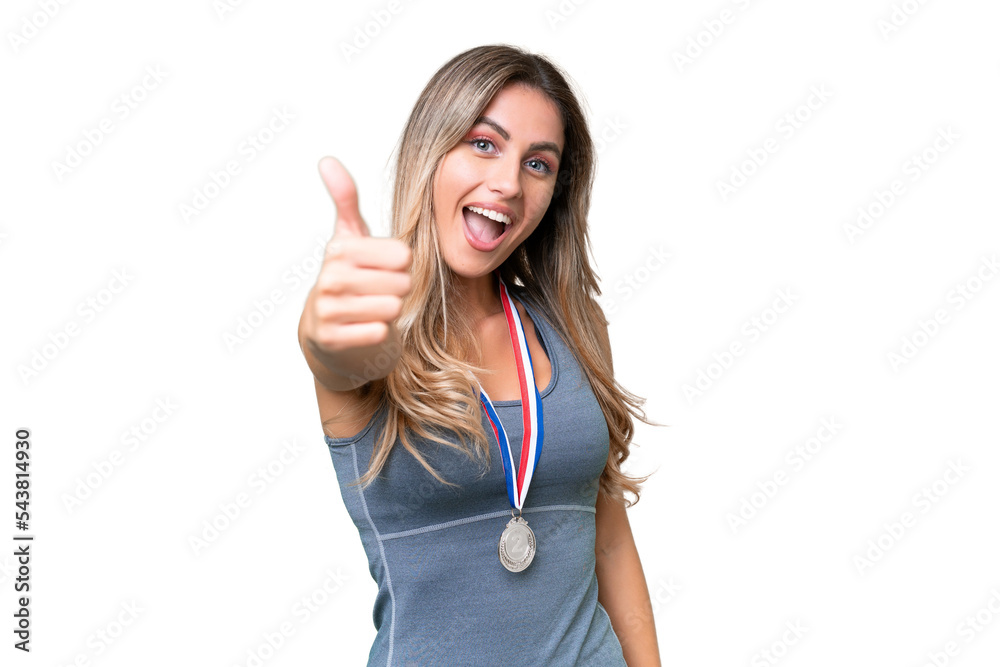 Young pretty sport Uruguayan woman with medals over isolated background with thumbs up because something good has happened Young pretty sport Uruguayan woman with medals over isolated background with thumbs up because something good has happened