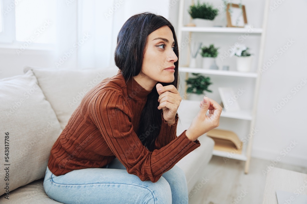 A woman looks sadly at a wedding ring in her hand, divorce and loss of a partner, breakup A woman looks sadly at a wedding ring in her hand, divorce and loss of a partner, breakup