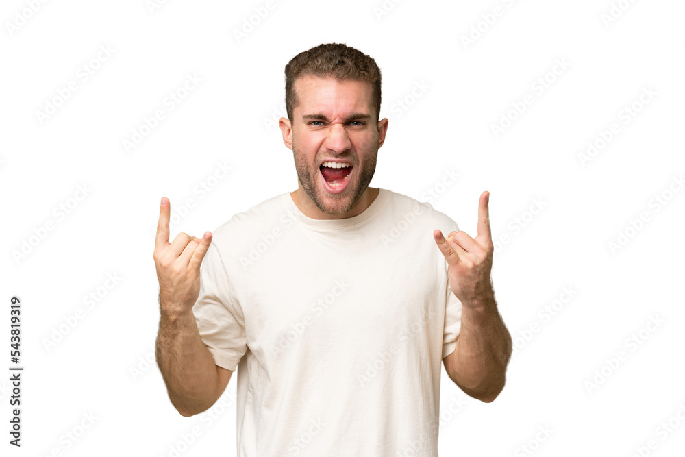 Young handsome caucasian man isolated on green chroma background making horn gesture Young handsome caucasian man isolated on green chroma background making horn gesture