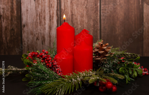 Advent - four red candles with a Christmas ornament. The first candle, the candle of the Prophet