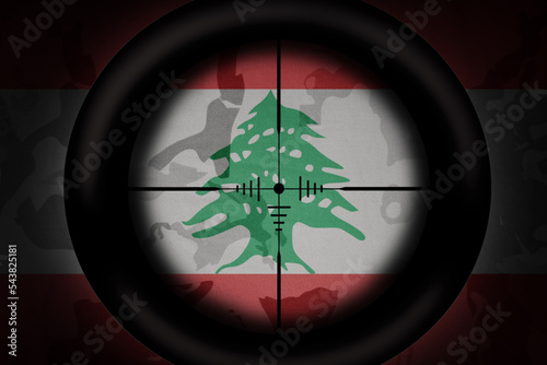 sniper scope aimed at flag of lebanon on the khaki texture background. military concept. 3d illustration photo