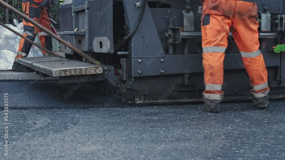 Fototapeta premium Road Paving Machine Roadworks Asphalt Laying Machine Operated by Workers Wearing Protective Workwear
