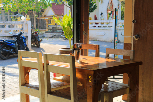 Wooden table and four chair with background is temple