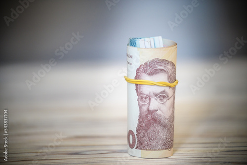 new Ukrainian hryvnia. 1000 hryvnia on wooden table bind with rubber tape to tube. money background and wealth concept photo