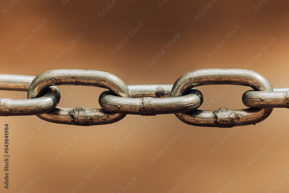 Close up chain links on sepia colored backdrop as old connection concept Close up chain links on sepia colored backdrop as old connection concept