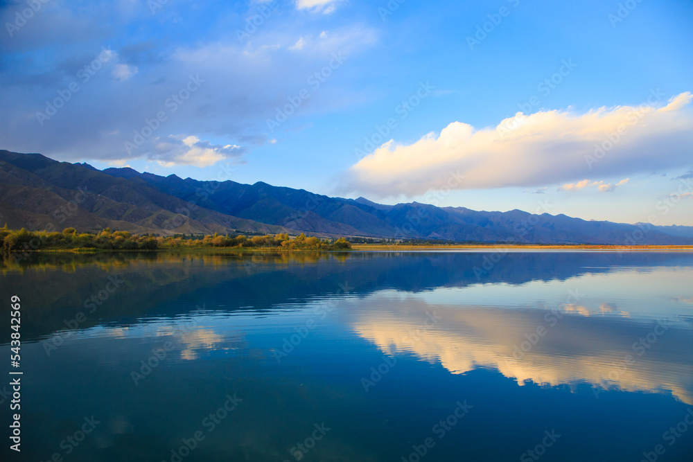 Lake in the mountains. Beautiful nature, reflection of clouds and mountains in blue water. Kyrgyzstan, Lake Issyk-Kul