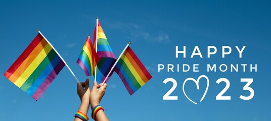 'HAPPY PRiDE MONTH 2023' on bluesky and rainbow flags background, concept for lgbtq+ celebrations in pride month, june, 2023.	