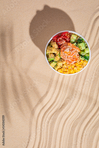 Hawaiian traditional food poke bowl on sand photo